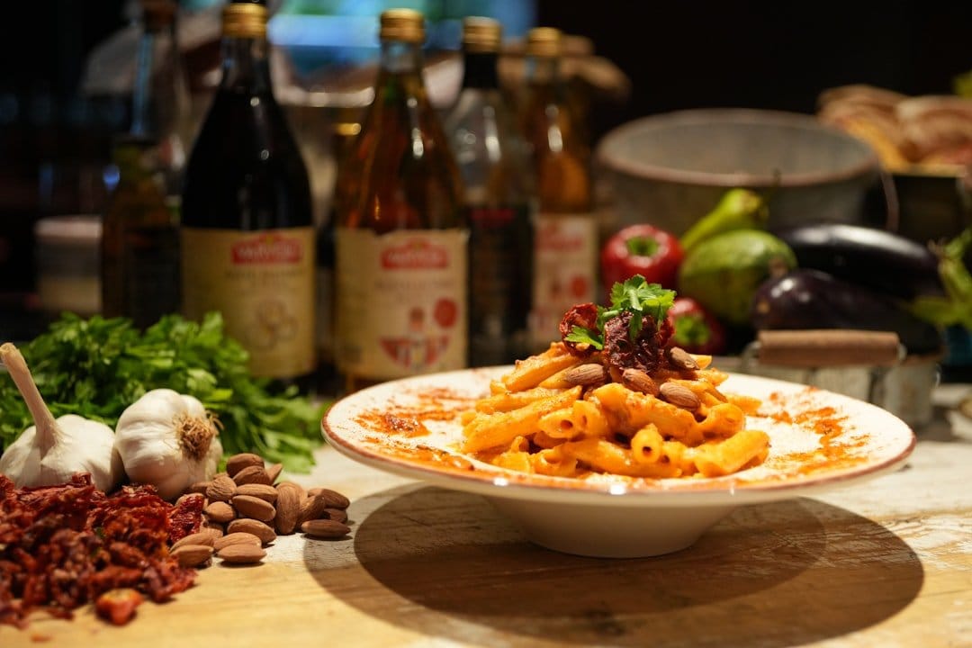 Fresh seasonal ingredients displayed on a rustic wooden table, highlighting vibrant tomatoes, herbs, and Italian cooking essentials.