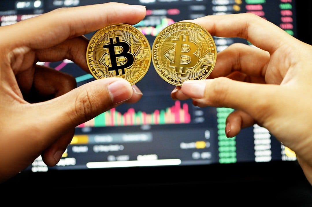 Katie Haun speaking at a conference, with a backdrop showcasing cryptocurrency symbols and investment graphics.