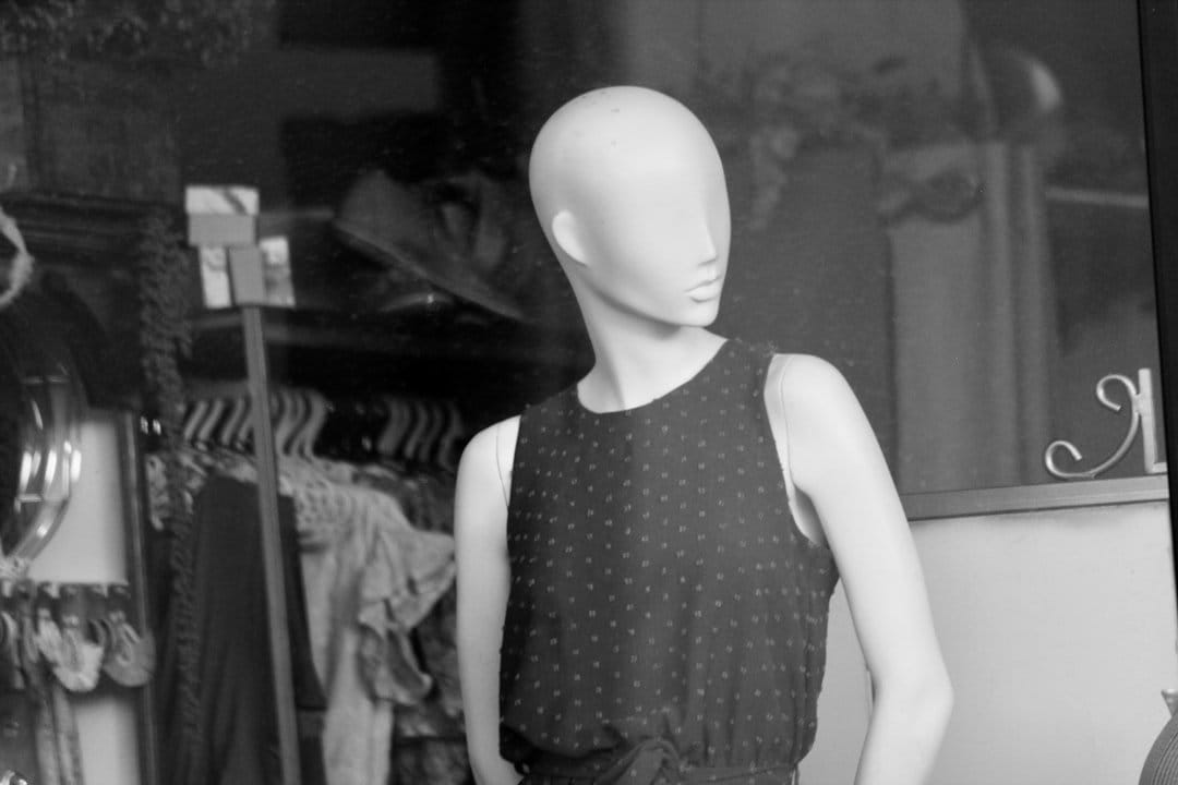 A model wearing a stylish jacket with patterns designed to confuse facial recognition technology, showcasing privacy-focused fashion.