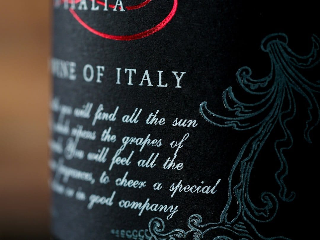Elegant table setting at an Italian restaurant featuring wine glasses, a bottle of red wine, and delicious pasta dishes.