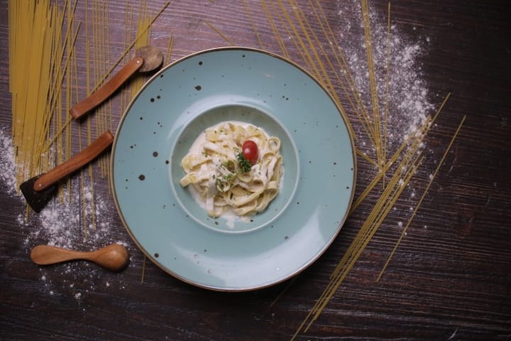 Fresh seasonal ingredients displayed on a rustic wooden table, showcasing vibrant vegetables and herbs for Italian cooking.