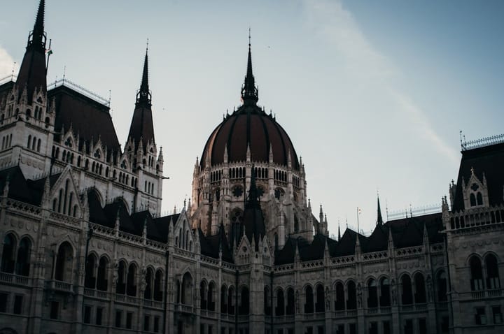 A diverse group of policymakers discusses AI regulations in a European setting, emphasizing cognitive sovereignty and innovation.