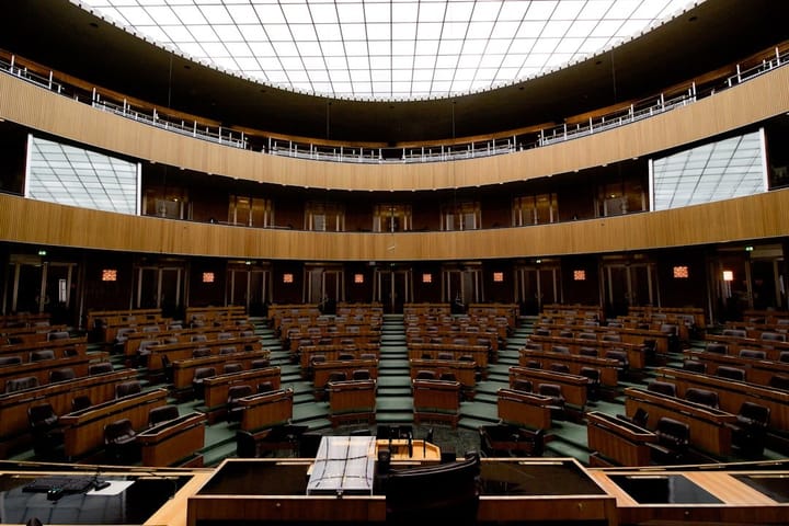 A European Union meeting with officials discussing the new Omnibus Deal, highlighting regulations on nudification apps and AI.