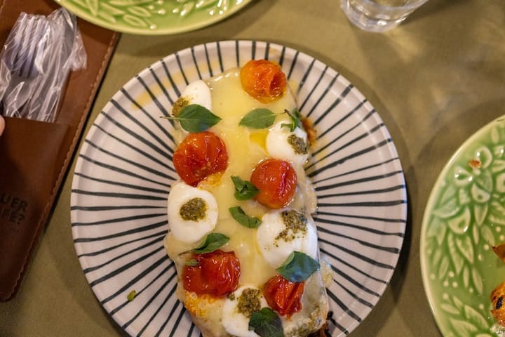 Fresh Caprese salad with ripe tomatoes, mozzarella, basil, and drizzled balsamic glaze on a rustic wooden table.