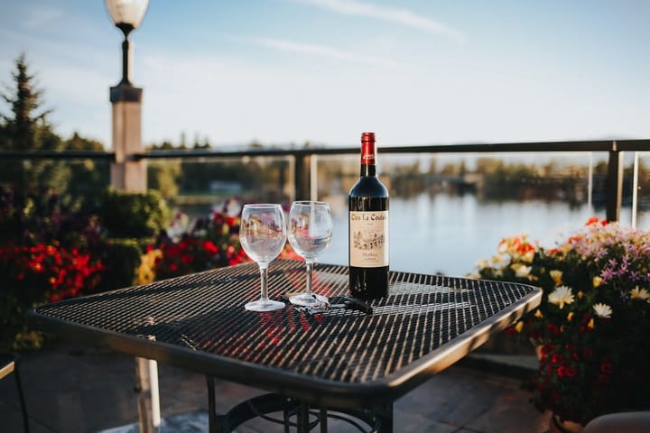 Elegant table setting at an Italian restaurant featuring wine bottles, glasses, and gourmet dishes, highlighting wine pricing issues.