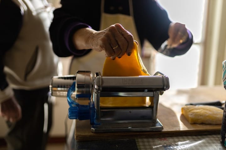 Freshly made pasta laid out on a wooden surface, showcasing the smooth texture and vibrant color of the dough.
