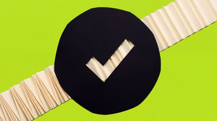 Cream accordion file passes behind a black paper circle with a check-shaped viewing window.